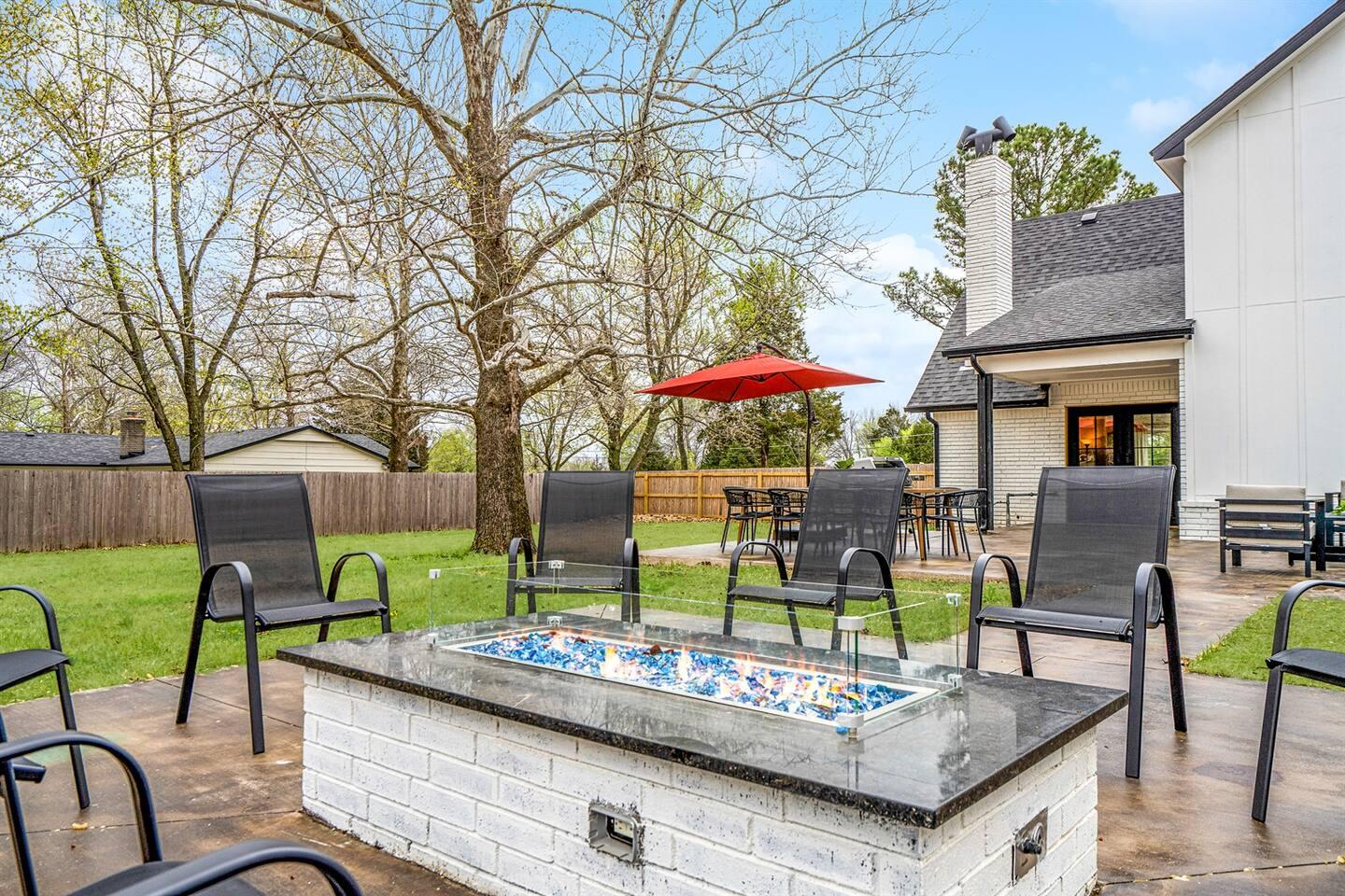 Gas fire pit with seating for ten on the back patio of the Estate at Sunset at dusk